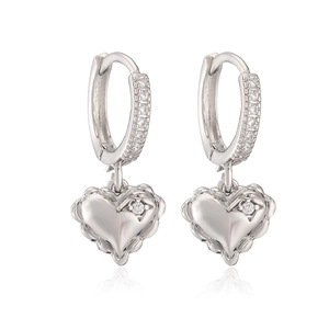Macro shot of silver heart drop earrings with shimmering zircon stones on white background