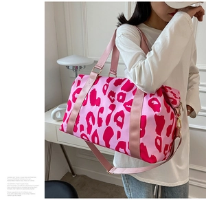 Close-up of pink leopard print travel bag showing fabric texture and sturdy straps