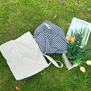 Top view of large plaid canvas tote bags on grass with a minimalist forest style