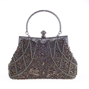 Dettaglio borsa da sera vintage con ricami di perline e manico in metallo decorato