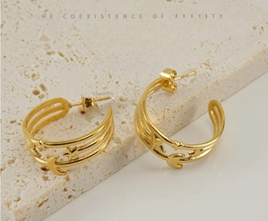 Detail of 18K gold-plated C-shaped earrings with hollow star and moon patterns
