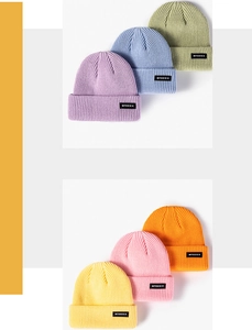 Detail of ribbed knit beanies in vibrant colors with stylish woven letter patches