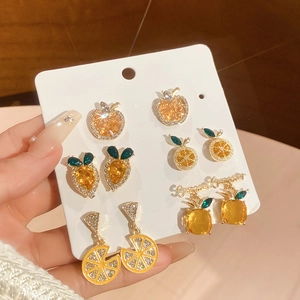 Detail view of sparkly apple and pineapple earring set with gold base and rhinestones