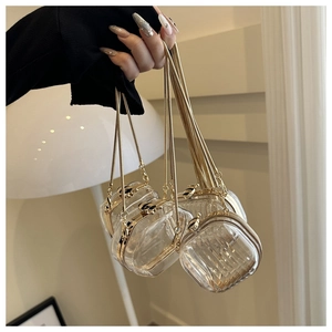 Detail of four transparent acrylic mini box bags with gold frames and elegant chain straps