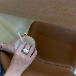 Anillo de gota irregular plateado pulido y pulsera de cuentas en un ambiente casual