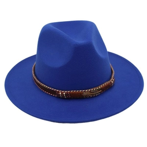 Detail of royal blue wool fedora featuring a gold feather metal pin and braided leather band
