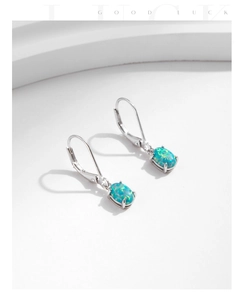 Macro view of s925 sterling silver earrings with oval opal in a four-claw setting