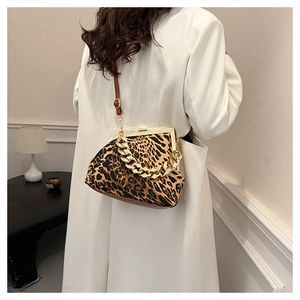 Detail view of leopard print bag with golden chain and adjustable brown leather strap