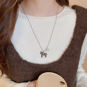 Vue détaillée des pendentifs cheval plaqués or 18K sur collier à chaîne argent