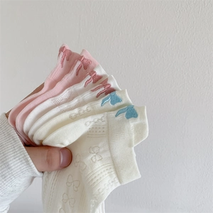 Detail of breathable cotton boat socks featuring bow embroidery and hollow lace patterns