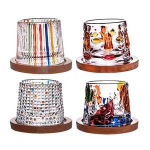 Set of four rotating whisky glasses with colorful hand-painted patterns and wooden bases