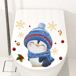 Close-up of cute cartoon penguin sticker with festive winter elements on a toilet lid