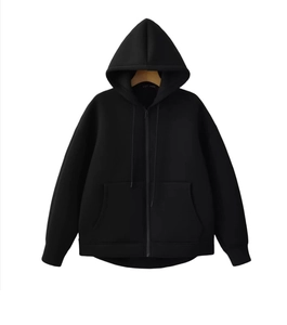 Close-up of black oversized zip-up hoodie featuring deep side pockets and drawstring hood