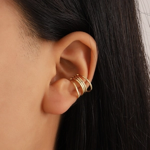 Detail of gold multi-layer U-shaped ear cuff showing minimalist geometric wrap design