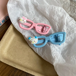 Close-up of cute cartoon cat eye-glass hair clips in pink and blue pastel colors