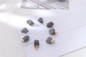 Macro view of natural crystal birthstone pendants with gold-plated edges and metal loops