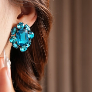 Gros plan de boucles d'oreilles vintage flocon avec grand cristal bleu et accents diamants