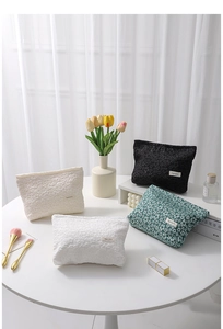 Detail of assorted floral and embossed cosmetic bags with zipper closure and woven label