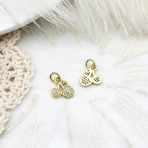 Detail of micro-paved cherry charm with gold finish and honeycomb cutout for DIY jewelry