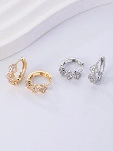 Detailed close-up of gold and silver hoop earrings with triple flower zircon inlay