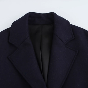 Close-up of lapel collar on navy blue wool blend coat showing fabric texture and stitching