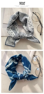 Detail view of cotton-linen scarves with paisley and floral patterns tied in elegant knots