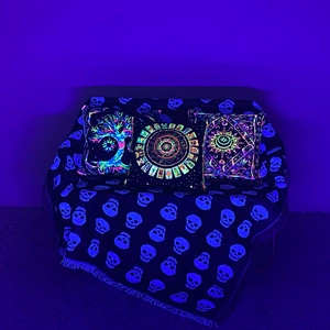 Detail of UV reactive bohemian pillow set and skull throw blanket with fluorescent glow