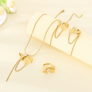 Detailed view of gold bow jewelry set with crystal stones and long tassel chains