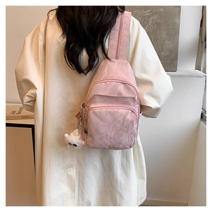 Vista posteriore modella con borsa a tracolla rosa plissettata e ciondolo in peluche