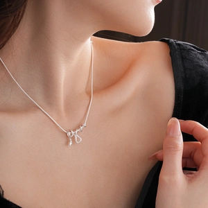 Macro della collana con ciondolo a serpente d'argento su modella con finitura lucida