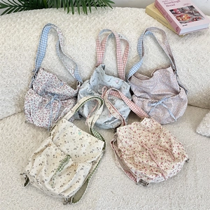 Flat lay of floral canvas drawstring bags with colorful patterns and gingham straps