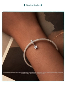 Détail d'un bracelet en maille argentée avec breloque étoile scintillante au poignet
