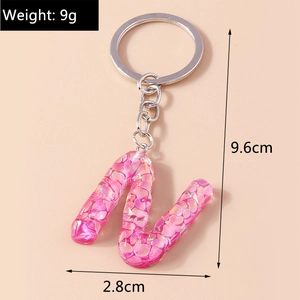 Pink glitter resin letter N keychain showing dimensions 9.6cm length and 9g weight