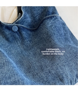 Close-up of blue denim fabric with white contrast stitching and matching buckle detail