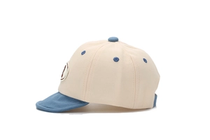 Détail de vue latérale d'une jolie casquette de baseball beige et bleue pour bébé