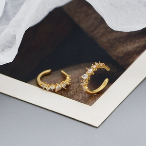 Macro view of gold S925 silver U-shaped clip earrings with sparkling zircon stones