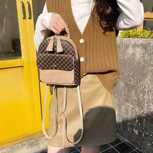 Mini floral print backpack in brown PU leather held by a model in an outdoor setting
