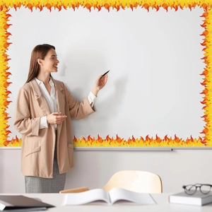 Enseignante montrant des bordures adhésives de flammes sur un tableau de classe