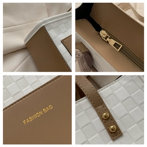 Detail view of brown leather tote with checkered texture and gold rivets