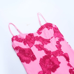 Détail du tissu jacquard rose avec fleurs 3D floquées sur une robe ajustée chic