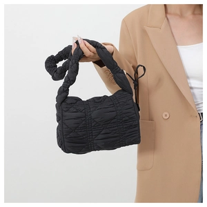 Close-up of quilted black nylon texture and scrunchie shoulder strap on the hobo bag
