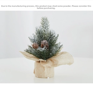 Detail of mini frosted PE Christmas tree with pine cones and rustic burlap base