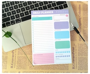 Close-up of English daily planner pad with goals and habit tracker on a desk