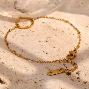 Dettaglio di un bracciale a perline placcato oro 18K con ciondolo a cuore su pietra