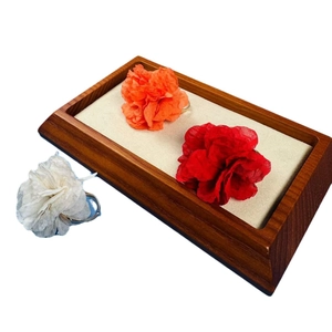Elegant floral fabric rings in red, white and orange on a professional jewelry display