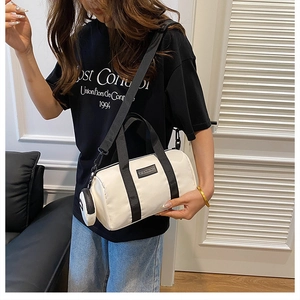 Close-up of white nylon Boston bag with black strap and mini round coin purse detail