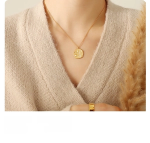 Close-up of 18k gold plated titanium steel necklace with shell and pearl pendant