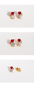 Close-up of heart-shaped red zircon and emerald cut gems on gold plated studs