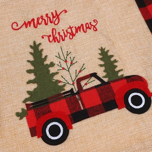 Close-up of burlap placemat with red buffalo plaid truck and merry christmas embroidery