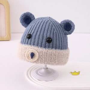 Dettaglio del cappello a orso con trama a coste blu e bordo in finta pelliccia beige